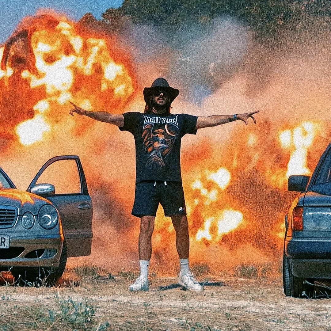 Clip rock : musicien bras écartés devant une voiture en flammes, explosion ajoutée en post-production