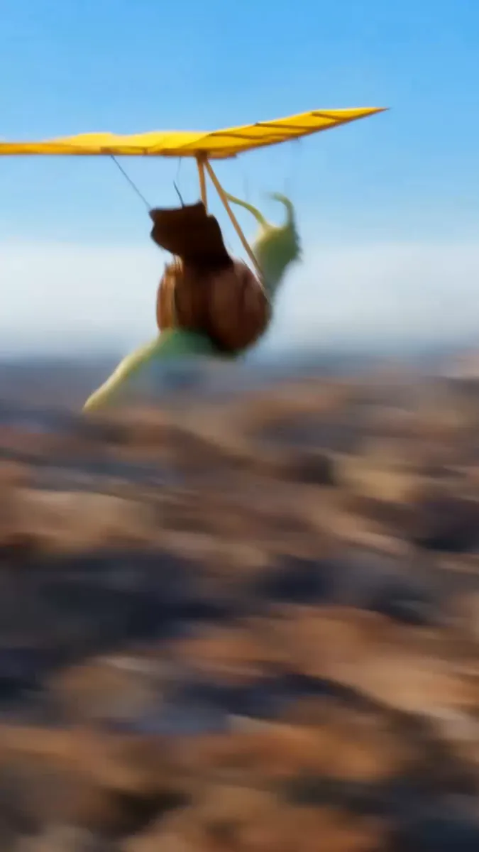 Image extraite d'une vidéo IA : mascotte escargot en parapente au-dessus d'une ville