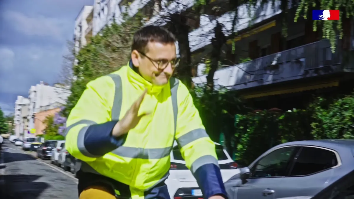 Tournage d'une campagne de sécurité routière : agent en gilet jaune dans la rue