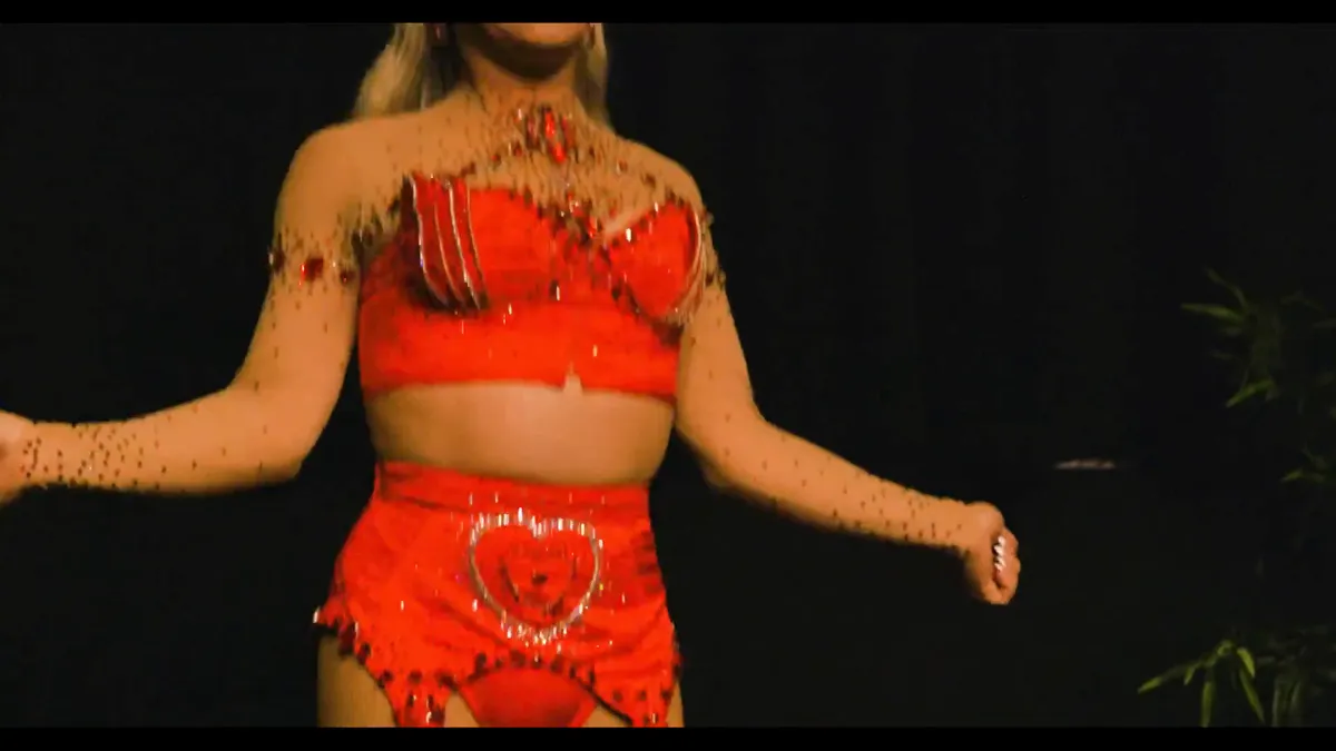 Tournage d'une performance sur scène : artiste en tenue rouge, plan serré