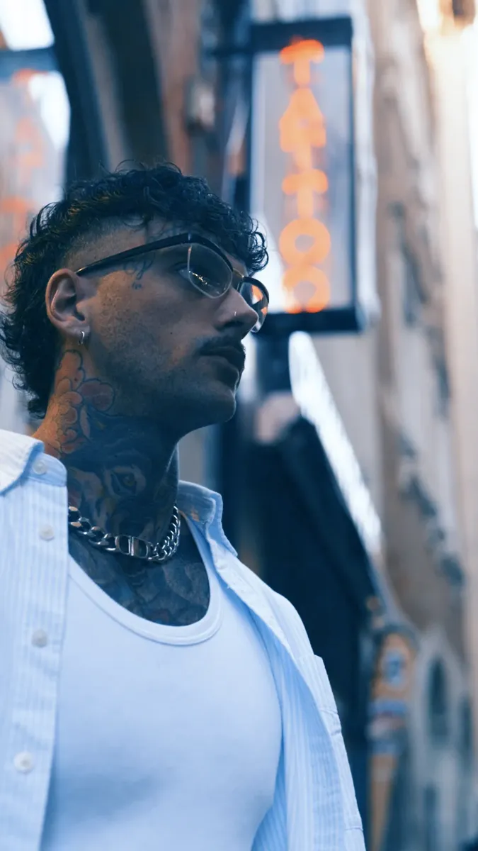 Tatoueur filmé dans une ruelle en lumière de fin de journée